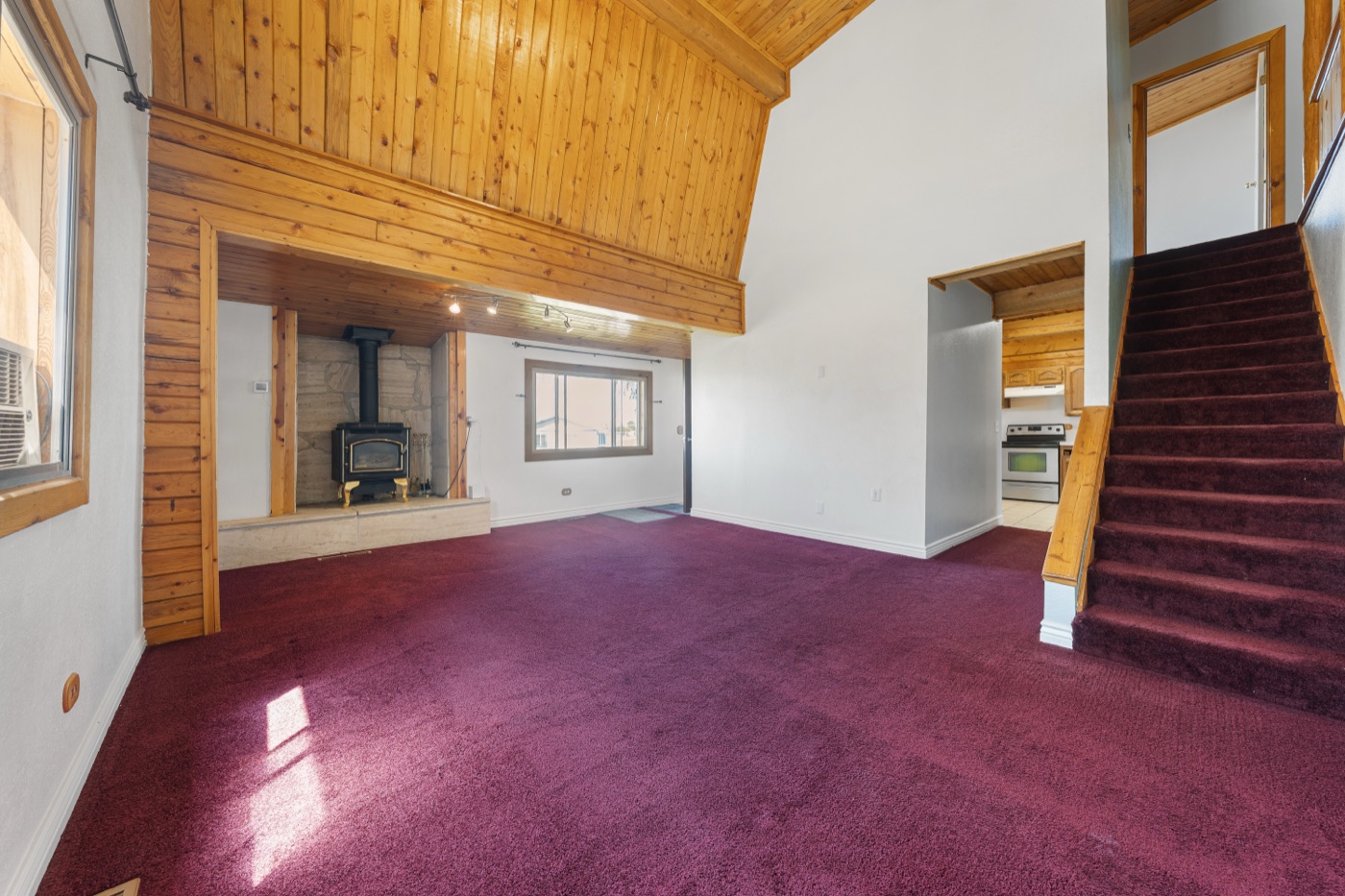 Living room view showing kitchen entry and stairs to loft